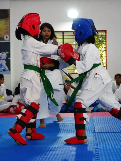 Two green belt students spar during a belt grading exam. These matches are a practical test of the skills they have learned.