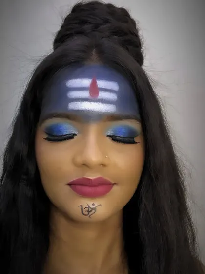 A Mahashivratri-inspired makeup look, featuring the iconic 'tripundra' on the forehead and a powerful blue smokey eye. These creative looks are a fantastic way for students to practice precision and artistry.