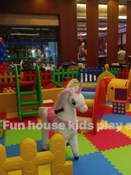 A view of the rainbow play area from the entrance, showcasing the rocking horse and colorful safety mats.