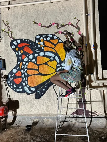 Another angle of me working on the butterfly, showing the dedication it takes to complete these large outdoor pieces.