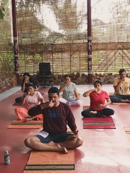 Participants practicing alternate nostril breathing to balance their energy.