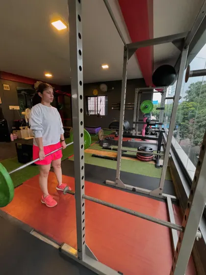 A client prepares for a deadlift in the squat rack, ready to take on a challenging set.
