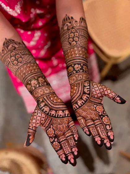 A full view of a bridal design with elephant and peacock motifs on the forearms.