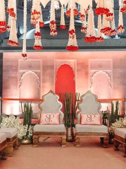 The elegant seating for the bride and groom at the mandap, personalized with their initials.