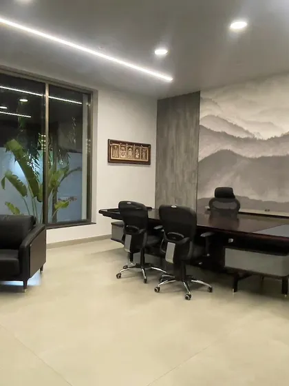 The director's cabin at VEE CEE EXPORTS, featuring a custom art panel depicting mountain ranges. The design combines modern furniture with artistic elements to create a powerful and serene workspace.