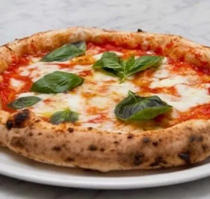 The quintessential Neapolitan pizza: the Margherita. This simple yet perfect pizza features San Marzano tomato sauce, fresh mozzarella, basil, and a drizzle of olive oil on a beautifully baked crust.
