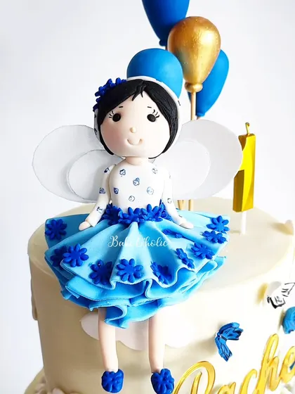 A close-up of the beautiful, handcrafted fairy topper, complete with delicate wings and a ruffled dress.