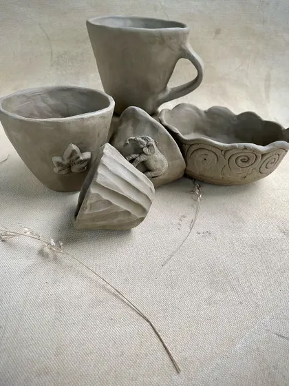 A duplicate of image 30, showing the collection of unfired hand-built pieces. Each item reflects the individual creativity of the student who made it.