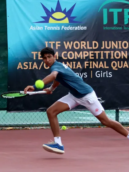 A dynamic shot of Tavish Pahwa hitting a forehand on the run during the ITF World Junior Team Competition. This demonstrates the ability to generate power even when under pressure.
