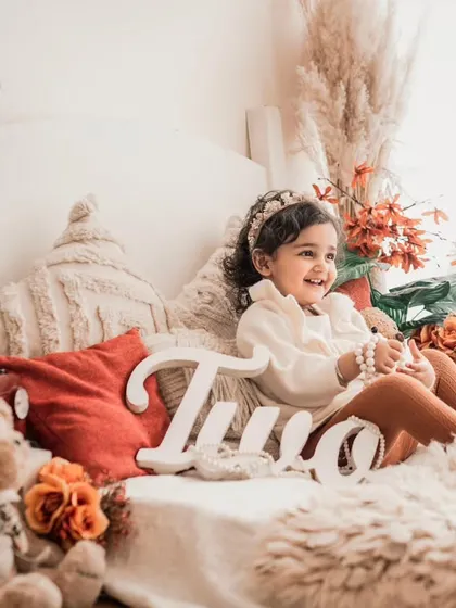 Celebrating two years old with a cozy, rustic-themed photoshoot. The warm tones and natural textures create a beautiful and timeless setting for a toddler's birthday portrait.