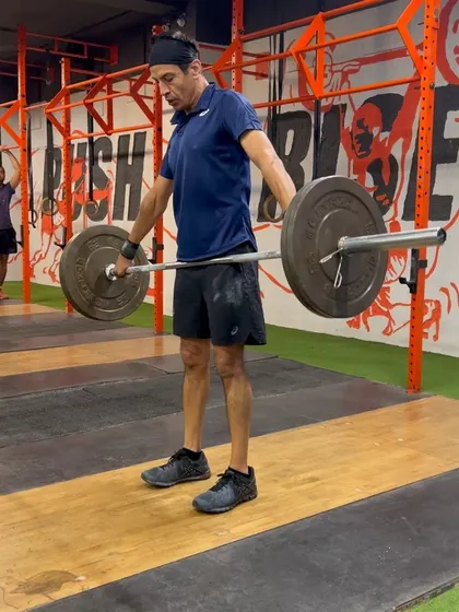 This image shows the correct starting posture for a hang snatch from just above the knee. This position helps develop power and proper bar path through the middle of the lift.