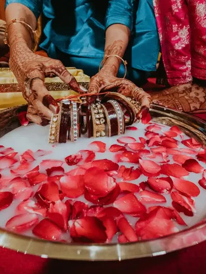 A detail shot from a Chooda ceremony, where the traditional bangles are purified in a bowl of milk and rose petals. I focus on the beauty of these rituals.