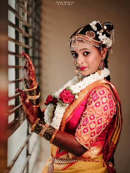 Another beautiful window-lit portrait of the bride, capturing her elegance and the richness of her traditional wedding look.