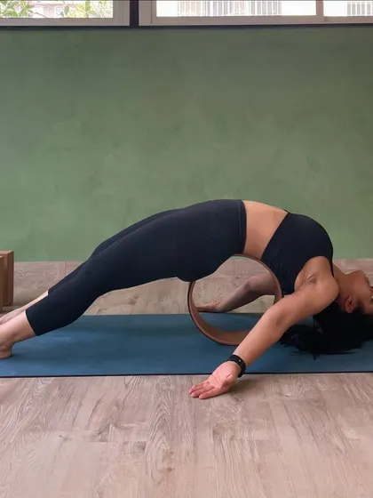 A student uses a yoga wheel to support a deep backbend, opening the entire front of the body. We have every prop you can imagine.