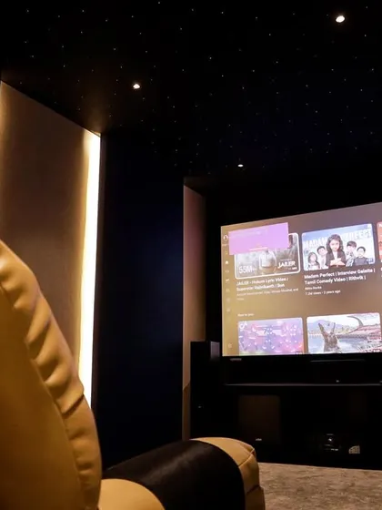 A view from the side of the recliner, showing the immersive experience of watching a movie on the large screen in this intimate setting.