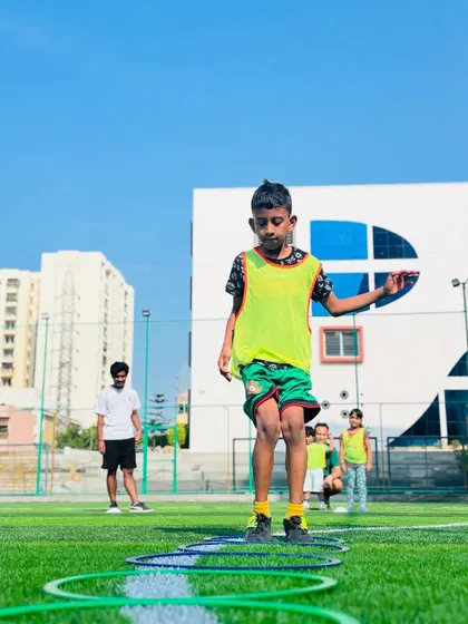 A young boy carefully navigates an agility ladder. These drills are excellent for developing footwork, speed, and concentration in our budding football players.