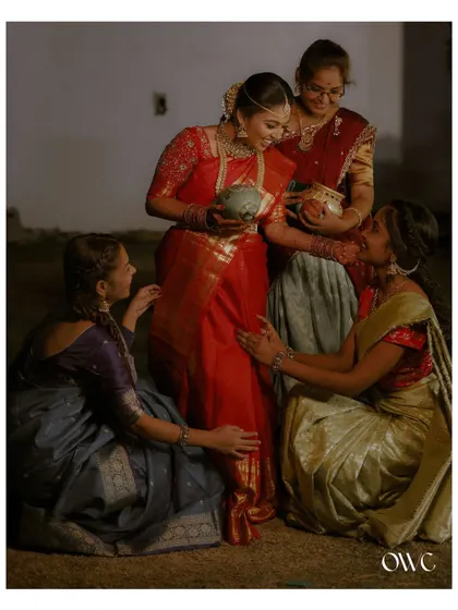 A sweet moment between the bride and her bridesmaids during a pre-wedding ritual.