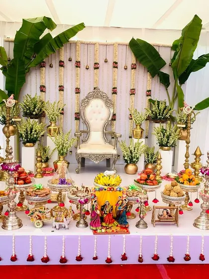 A complete view of a grand Seemantha setup, featuring large cow figurines. The traditional backdrop with banana leaves and a full 21-plate offering display makes for a truly auspicious setting.
