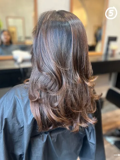 A beautiful example of a layered cut paired with a soft brown color refresh. This look is all about enhancing natural beauty with subtle changes.