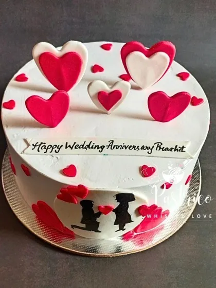 A classic anniversary cake with a romantic silhouette and cascading red and white hearts.
