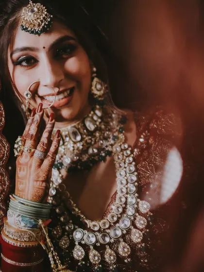 A creative shot of a bride, with a foreground element creating a sense of looking in on a private, happy moment.