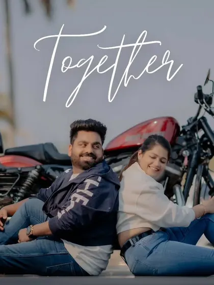 "Together." A fun and relaxed shot of the couple sitting back-to-back on the road with their motorcycle. This image captures their adventurous spirit and easy-going love.