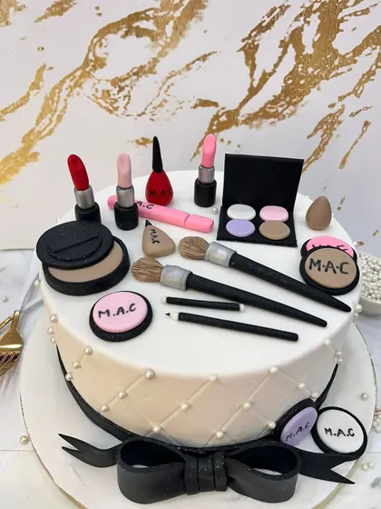 A makeup artist's dream cake. This design is covered in edible, handcrafted MAC makeup items, including lipstick, brushes, and eyeshadow palettes.