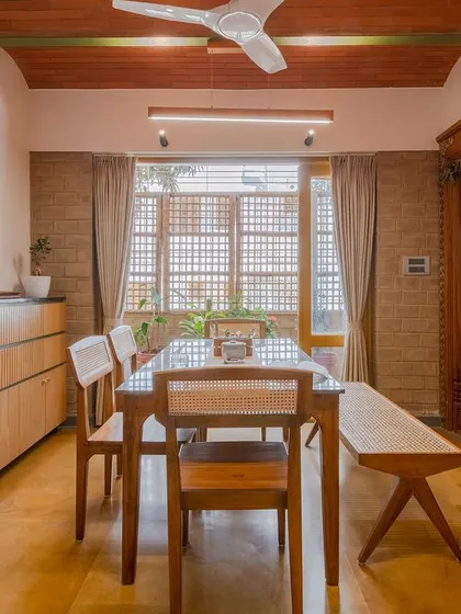 The dining area sits under a jack-arch roof, a traditional technique that adds character and volume. The space opens to a sit-out, blurring the line between inside and outside.