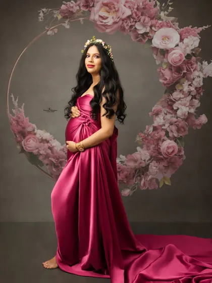 An elegant portrait of a mother-to-be framed by a beautiful floral hoop. The rich color of the gown and the soft floral elements create a perfect balance.