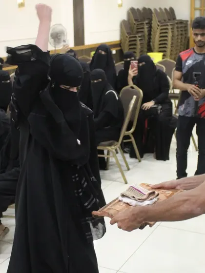 The moment of truth. A participant raises her fist in triumph after successfully breaking a brick during our women's empowerment workshop, a powerful symbol of overcoming fear and discovering her own strength.