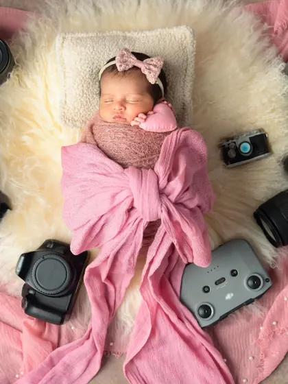 Wrapped up like a beautiful gift with a giant pink bow, our tiny photographer is ready for her debut.