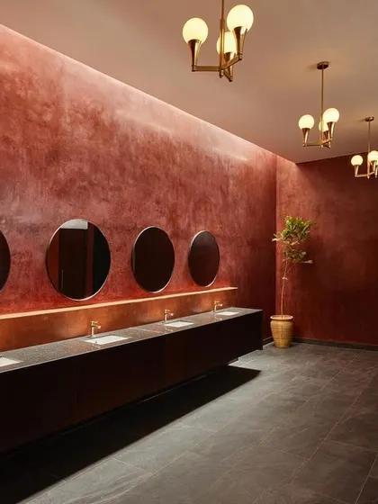 Another view of the restroom, showcasing the long vanity counter and the warm glow from the pendant lights. I wanted to challenge the idea of what a utilitarian space can be.