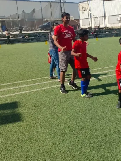 A father and son team up for a fun drill at our Community Fest, highlighting the bond we build within our football family.