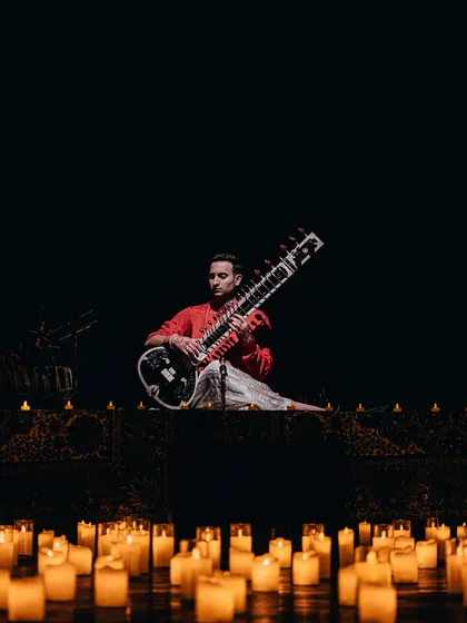 The iconic candle-lit stage setup for the 'Sitar for Mental Health' tour, creating a warm and inviting atmosphere.