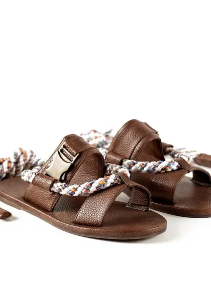 A pair of brown leather sandals with unique rope ties from Jeetinder Sandhu. This shot captures the artisanal and bohemian feel of the design.