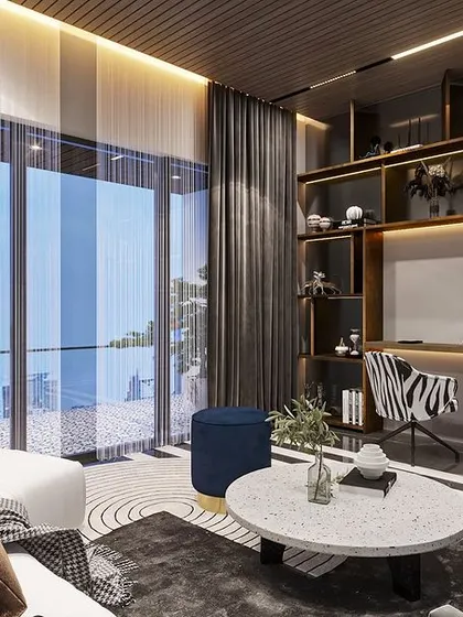 The same living area includes a functional study nook with an integrated desk and backlit shelving, showing how we blend work and leisure spaces seamlessly.