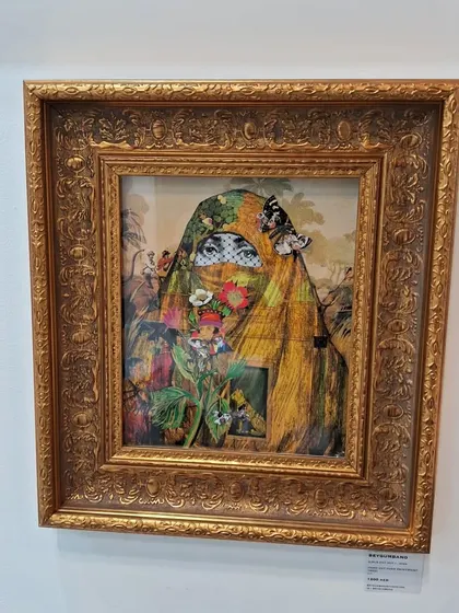 An ornate, gold-framed artwork by Beygum Bano featuring a veiled figure adorned with flowers and butterflies.