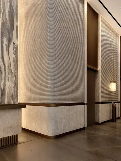 A corridor in the commercial tower, where a material palette of natural stone and textured metal reflects both strength and serenity. The design is an architectural overture, setting the tone for a high-design experience.