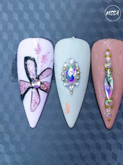 A trio of glamorous designs. This set includes a glittery hand-painted flower and two different styles of intricate crystal placement on a stiletto nail.