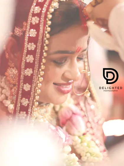 A soft-focus, artistic shot of the sindoor ceremony. This creative approach highlights the bride's smile and the emotional weight of this beautiful wedding ritual.