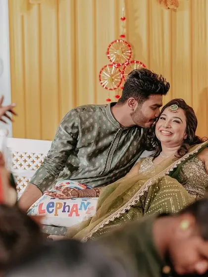 A candid, loving moment between the couple during their Mehendi ceremony, surrounded by friends and family.
