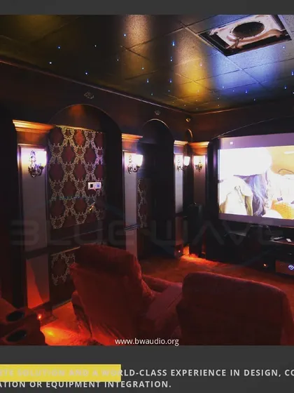 A close-up view of a classic theater with patterned wall panels and a starlight ceiling. The warm, ambient lighting and luxurious materials create an inviting and high-end entertainment space.