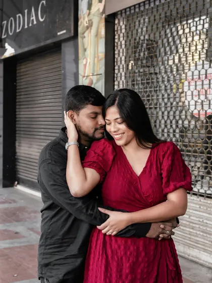 A sweet and tender moment on a city street, where the groom-to-be gently holds his partner.