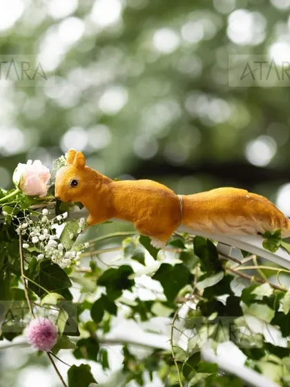 A close-up of a squirrel prop on a floral arch from a woodland-themed event. It's these small, charming details that make my events feel truly alive and magical.
