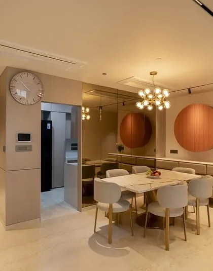 The dining area of a modern apartment I designed at Oberoi Sky City. The space is defined by a marble-top table, contemporary chairs, and a unique circular wall cabinet that doubles as art.
