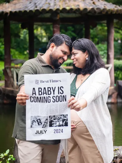 A creative pregnancy announcement using a custom newspaper prop. This is a fun and unique way for couples to share their exciting news during an outdoor photoshoot.