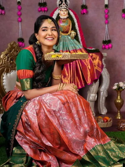 A happy model celebrating Varamahalakshmi pooja. She is wearing our simple yet elegant gold-finish choker and jhumkas, perfect for the occasion.