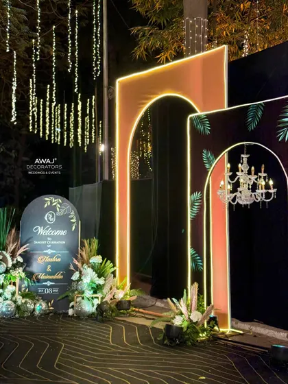 The welcome area for the Sangeet, featuring a custom sign and floral arrangements that match the modern, tropical theme.