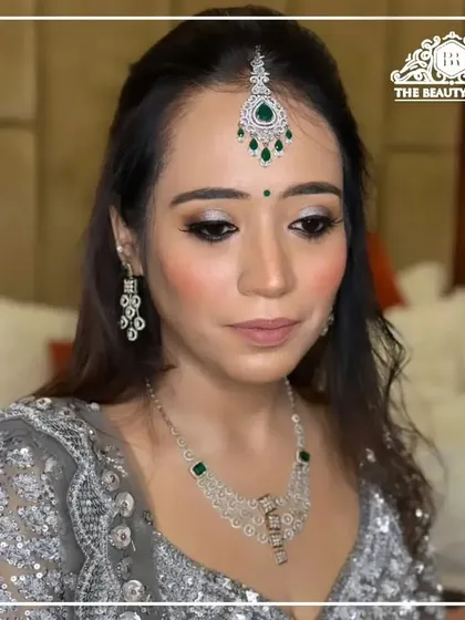 A sophisticated party look featuring silver glitter eyeshadow and a soft pink lip. This makeup is perfect for a reception or engagement, paired with a sparkling silver lehenga.