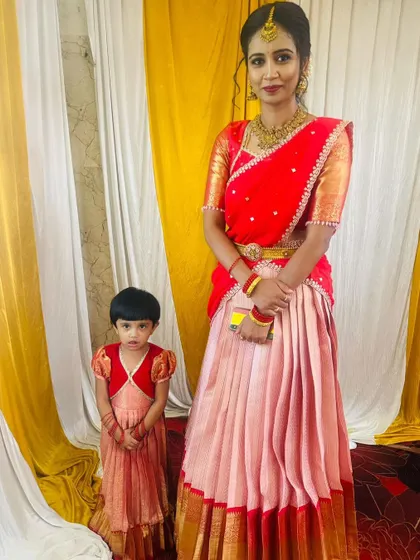 A classic mother-daughter combination for a traditional event. I designed this matching set with a modern Langa Davani for mom and a cute puff-sleeve frock for her daughter, both in coordinating shades of pink and red.